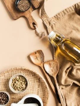 Kitchen flat lay of beige apron, small bowls with spices, olive oil in bottle Stock Photos