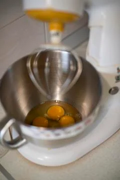 Kitchen front with planetary mixer with egg whites and yolks in a metalic bowl Stock Photos