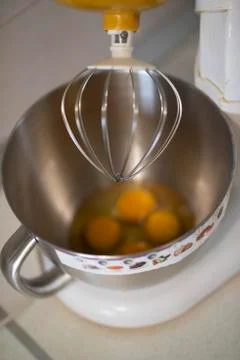 Kitchen front with planetary mixer with egg whites and yolks in a metalic bowl Stock Photos