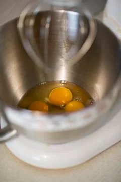 Kitchen front with planetary mixer with egg whites and yolks in a metalic bowl Stock Photos