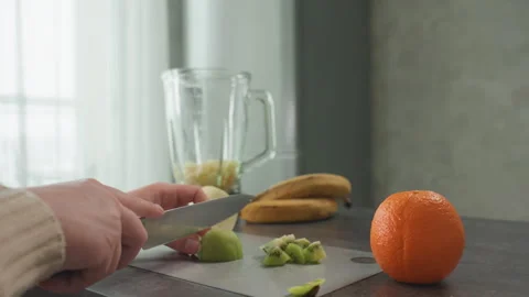 Kitchen fruit preparation. Pregnant individual making smoothie with fresh fruits Stock Footage 335542372