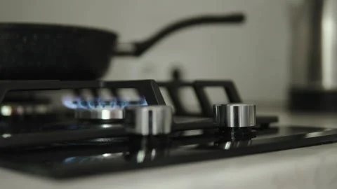 Kitchen gas hob knobs with burning gas burner close up. 스톡 동영상 301989926