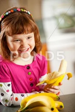 Kitchen girl: eating a banana Stock Photos