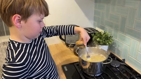 In the kitchen, a handsome young man is preparing a delicious sauce Stock-Footage 302930855