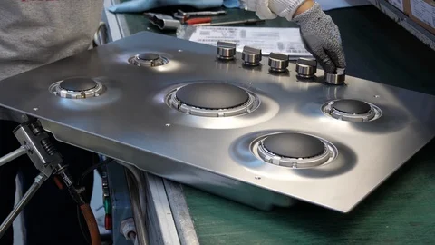 Kitchen hob factory, worker testing proper operation of the hob Stock Footage 94424109