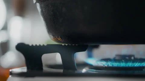 In the kitchen of the house, a gas stove is igniting the gas with a blue fla Stock Footage 249831364