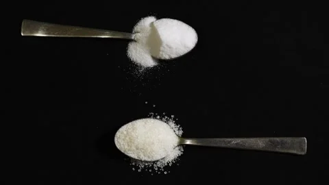 Kitchen ingredient concept with sugar and salt on separate spoons Stock Footage 336646032
