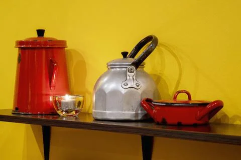 Kitchen interior with tableware, dishes, iron pan and teapot on a shelf Stock Photos