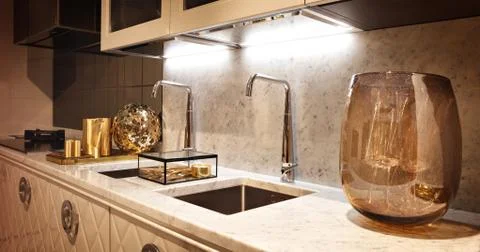 Kitchen Interior with two faucets in warm brown tones with glass accessories Foto stock