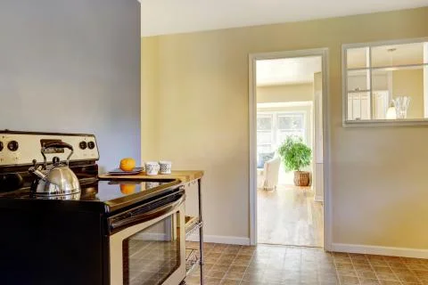 Kitchen interior with white cabinets, tile floor and bright navy walls Stock Photos