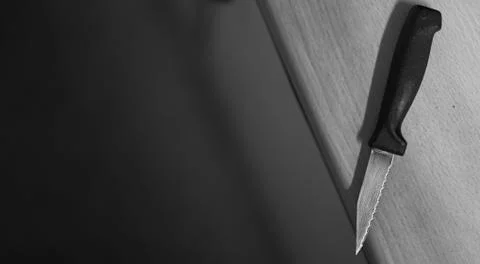 Kitchen knife on the edge of the table in black and white Stock Photos