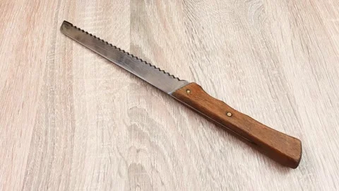 Kitchen knife with a serrated blade. Slicing knife with serrated steel blade. Video stock 270075391