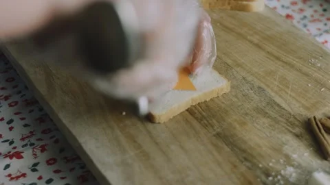 Kitchen knife trimming bread around a cheese template Stock Footage 342127153