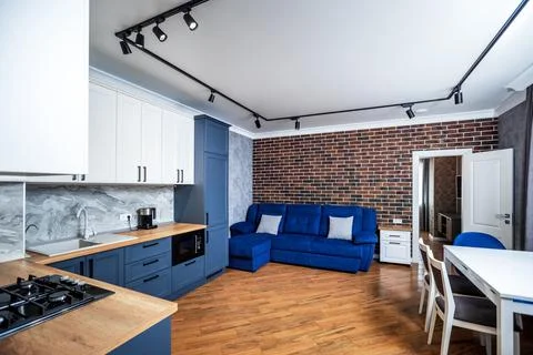 The kitchen is a loft-style studio in a blue beige tone. Stock Photos