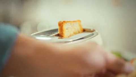 In a kitchen a mans hands carefully remove toasted hot bread from a toaster. Stock Footage 333501043
