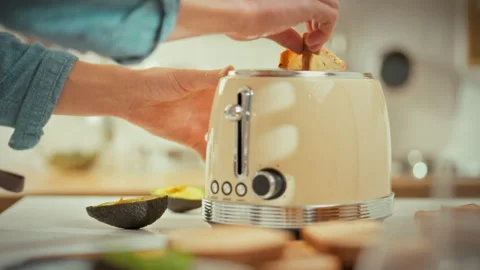 In kitchen mans hands pull the toaster lever down causing the hot toast to s Stock Footage 333501017