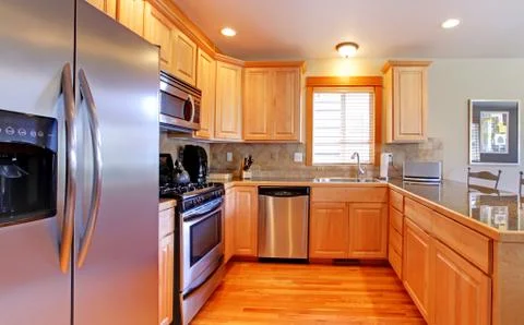 Kitchen with maple cabinets and new stainless steal appliances. Stock Photos