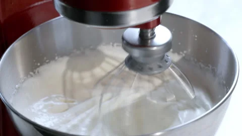 Kitchen mixer is beating the egg whites and sugar in the metal bowl. Stock-Footage 275250065