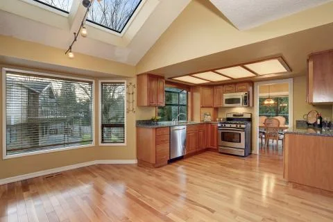 Kitchen with nice counters, stained cabinets and hardwood floor Stock Photos