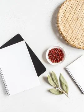 Kitchen notepad mock up for culinary text, wicker tray and spices on light ba Stock Photos