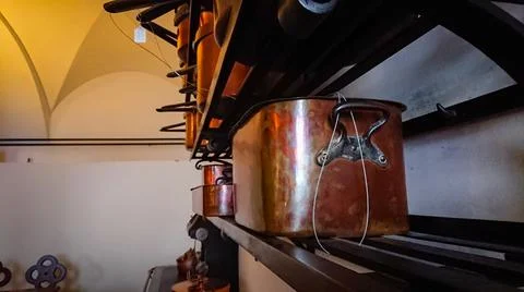 Kitchen of the old castle. Copper pans, baking molds and other kitchen utensi Stock Photos