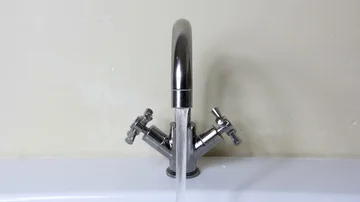 Kitchen or bathroom tap running water left on in sink basin Stock Footage 85680380
