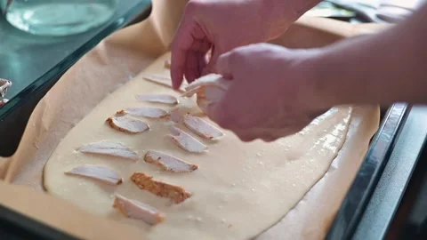 In a kitchen, a person is preparing a layered dish by adding various toppings Vidéo 339096350