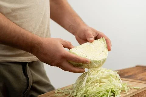 Kitchen preparation of cabbage, hands at work on a chopping board. Stock Photos