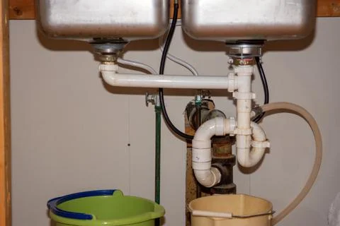 Kitchen Remodel Closeup of Under Sink Plumbing with Buckets Stock Photos