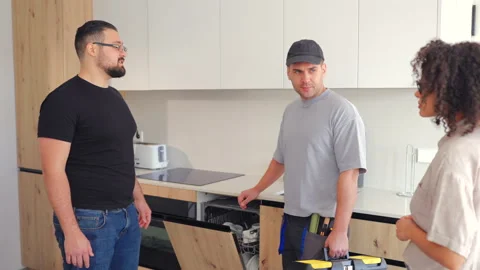 Kitchen repair specialist explaining appliance issue to homeowners Vídeo Stock 342961743