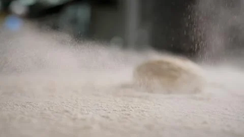 Kitchen in a restaurant, baking from flour. A chef sprinkles white wheat flou Stock Photos