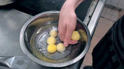 Kitchen. Restaurant. The cook separates the egg white from the yolk. Broken Stock Footage 171682855