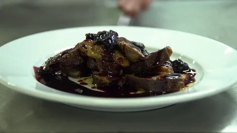 Kitchen. Restaurant. Cooking. The chef decorates meat, baked in foil with dried Stock Footage 73955102