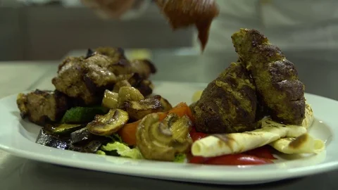 Kitchen. Restaurant. Cooking. The chef decorates meat grilled with vegetables Stock Footage 73955374