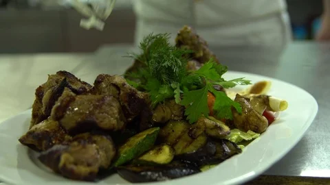 Kitchen. Restaurant. Cooking. The chef decorates grilled meat with vegetables Stock Footage 73955409
