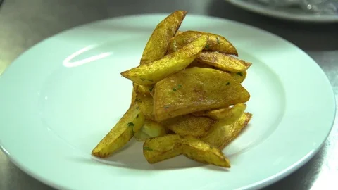 Kitchen. Restaurant. Cooking. The cook puts the meat on a dish with french fries Stock Footage 73954998