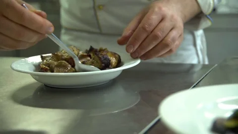 Kitchen. Restaurant. Cooking. The cook puts the meat grilled, on a platter with Video stock 73955296