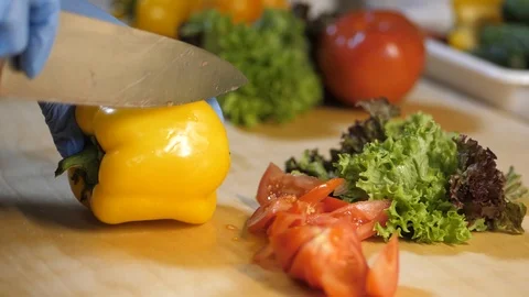 In the kitchen of the restaurant man cuts a bell pepper for salad. Stock Footage 126752429