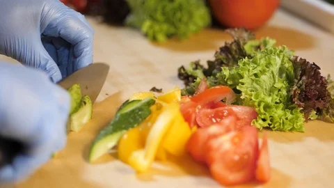 In the kitchen of the restaurant man cuts a cucumber for salad. Stock Footage 126752442