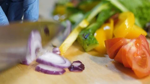 In the kitchen of the restaurant man cuts the onion for a salad. Stock Footage 126752444