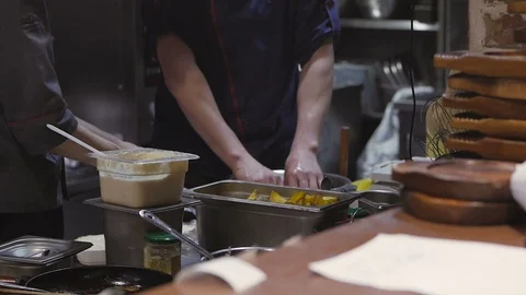 In the kitchen of the restaurant two chefs prepare a dish, in the frame you can Stock Footage 106330869