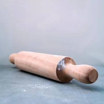 Kitchen rolling pin with flour on dark background selective focus depth of .. Stock Photos