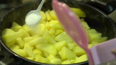 In the kitchen, salt is added to home-cooked potatoes Stock Footage 258131910