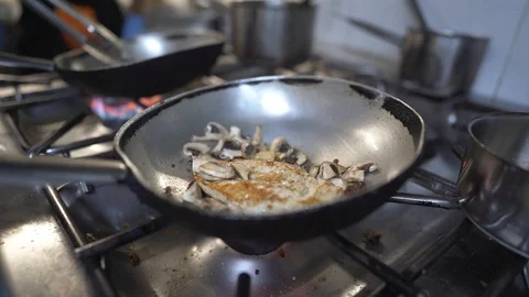 Kitchen scene with chef cooking chicken with mushrooms Stock Footage 128570841