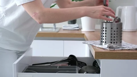 Kitchen scene showcasing the organized cutlery drawer, as hands reach for Stock Footage 315660771