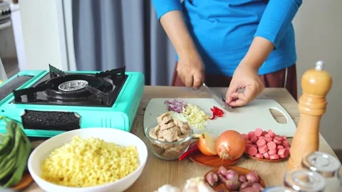 Kitchen scene showing hands slicing chili peppers on cutting board 库存影片 341487617