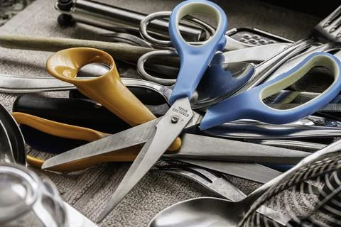 Kitchen scissors and cutlery cluttered in a drawer Stock Photos