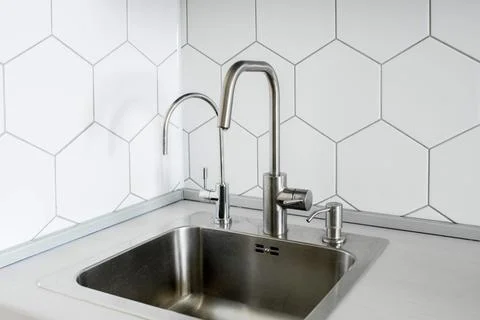 Kitchen setting featuring a stainless steel sink with a single-handle faucet Stock Photos