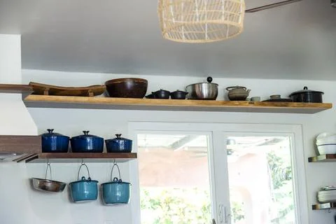 Kitchen shelf showcasing an array of cookware in a bright and airy space Stock Photos