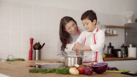 In the kitchen: A single-parent family cooking pasta together. Mother and son Stock Footage